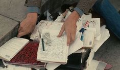 a person sitting on the ground with lots of books and papers in front of them