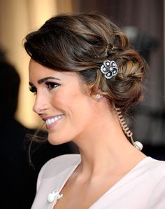 Louise Roe’s loose braided chignon with sparkly accents. Begin by drying the hair with a round brush. Then, loosely comb back the hair into a side ponytail. Finish the ends with a loose three-strand braid. Wrap and secure the braid with bobby pins around the base. Pull sections at the top of the head around the ponytail. Finish off with the latest trend of adding a sparkly headband or accents. Winter Hair Trends, Side Bun, Messy Bun Hairstyles, Wedding Hair Inspiration, Diamond Brooch, Winter Hairstyles, Wedding Hair And Makeup, Red Flower