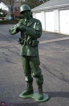 a statue of a soldier is standing in the middle of the street with his hands on his chest