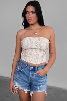 Faux leather embroidered western corset top. western style crop top features a lined material with boning. The design showcases a rope lace up detail that can be adjusted in the back. The unique asymmetric hem creates a hourglass silhouette. Perfectly styled with jeans and a pair of cowboy boots! Runs true to size measured on a size small Small: 2-4 length: 11.25" Medium: 6-8 length: 11.5" Large: 8-10 length: 11.75" MODEL DETAILS: Model is 5'8 Bust: 32 B Waist: 24" Wearing size Small Leather Tube Top, Crop Top Styles, Design Crop Top, Chic Romper, Summer Crop Tops, Cropped Tops, Cropped Tube Top, Cow Boy, Bralette Tops