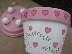 a pink pot with hearts painted on it