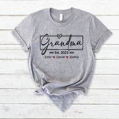 Custom Grandma, Grandma Est With Grandkids, Grandma Gift TH T-Shirt Great as Birthday gifts or Holiday presents. This adorable item can be designed upon anyone's wish with any title. All items are made to order. * Please be aware that the physical product's colors may differ slightly from the mockup. Brand: Gildan Classic unisex cut makes this easy to fit the body. Material: Heavyweight fabric Sport Grey And Antique Heathers: 90% Cotton | 10% Polyester Safety Colors And Heathers: 50% Cotton | 50 Shirt Names, Gifts For New Grandma, Holiday Presents, Great Grandma, Grandma Shirt, Personalized Gifts For Kids, Personalized Grandma, Grandma Shirts, Mom And Grandma