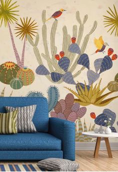 a blue couch sitting in front of a wall with cactus and plants on it's side