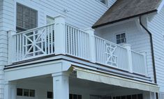 a white house with an attached porch and railing