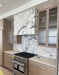 a kitchen with marble counter tops and cabinets