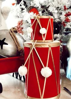 two red drums sitting next to each other on top of a table near a christmas tree