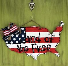 a sign that says land of the free with an american flag and bow on it