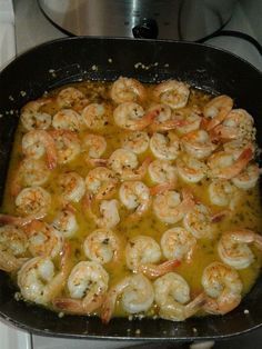 a pan filled with shrimp and sauce on top of a stove