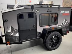 an off - road camper trailer parked in a garage