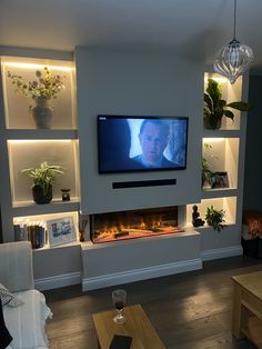 a flat screen tv mounted to the side of a wall next to a fire place