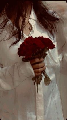 a woman holding a bouquet of red roses in her left hand and wearing a white shirt