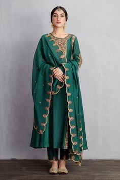 Bottle green flared long kurta with all-over aari worked motifs and side panels. Comes with handwoven chanderi pants and scallop border dupatta.
Component: 3
Embroidered
Neckline: Round
Sleeve Length: Full
Fabric: Kurta and Pant: Handwoven Chanderi and Cotton Voile; Dupatta: Handwoven Chanderi
Color: Green
Side panels
Churidar sleeves
Scallop cutwork - Aza Fashions Embroidered Neckline, Kurta With Pants, Manish, Bottle Green, Churidar, Kurta Set, Cotton Voile, Cut Work, Designer Wear