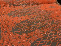 an orange and black bedspread with sequins on it