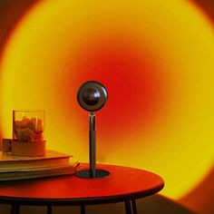 a red table with a black speaker on it and a yellow light in the background