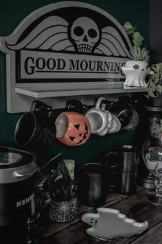 a shelf filled with cups and mugs next to a sign that says good mournin