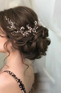 a woman wearing a tiara with flowers on it's head and hair comb