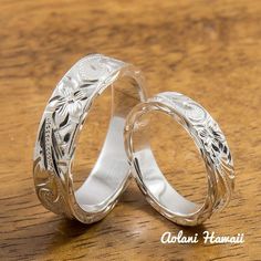 two wedding rings sitting on top of a wooden table