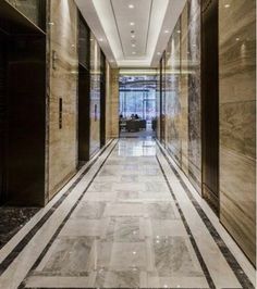 an empty hallway with marble floors and walls