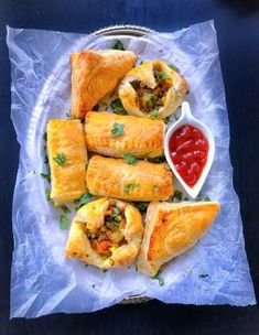 several pastries on a plate with dipping sauce