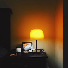 a lamp that is sitting on top of a desk next to a computer monitor and keyboard