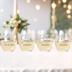 four wine glasses with names on them sitting on a table