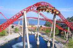 an amusement park with a roller coaster going over the water