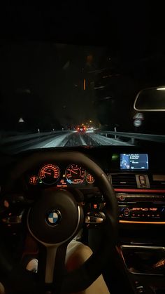 the interior of a car driving at night with its lights on and dashboard illuminated up