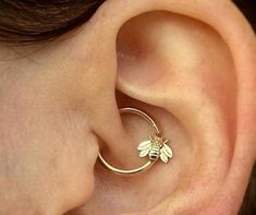 a close up of a person's ear with a bee on it