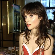 a woman in a red and white dress looking at the camera