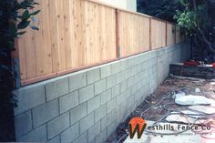 a wooden fence next to a brick wall