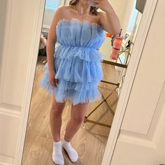 a woman taking a selfie in a mirror wearing a blue dress and white socks