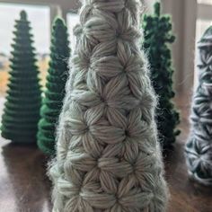 a knitted christmas tree sitting on top of a wooden table