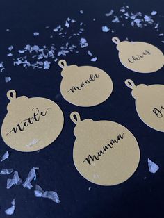 four tags with names on them sitting on a table