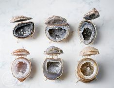 "Gorgeous one of a kind geodes are cut open to showcase their shimmering druzy centers. Encased in a custom fit gold brass frame, these make for the perfect jewelry boxes to store your most precious treasures. You will receive SIX geode ring boxes SIMILAR to the ones in the photos. These are priced at wholesale rates and sold in sets of 6. Your 6 geode ring boxes will be randomly selected from our inventory, we are not able to photograph and pick specific colors for you. The photos represent a s Geode Jewelry Holder, Geode Display Ideas, Geode Ring Box Proposal, Geode Ring Box Wedding, Geode Ring Holder, Crystal Ring Box, Unique Ring Box Ideas, Geode Display, Geode Ring Box