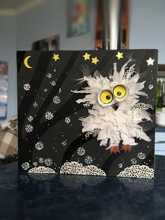 an owl with yellow eyes and stars on it's head sits in front of a black card