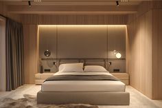 a large bed sitting in the middle of a bedroom next to a wall mounted light