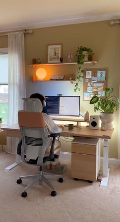 a home office with a desk, chair and computer on the table in front of a window