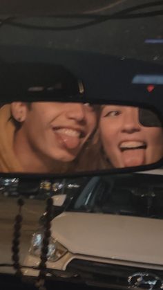 two people are seen in the rear view mirror of a car as they look at each other