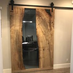 a room with a large wooden door that has been cut open to reveal a computer desk