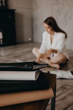 a woman sitting on the floor next to books