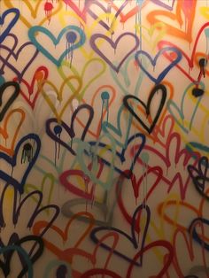 the wall is covered in graffiti and hearts