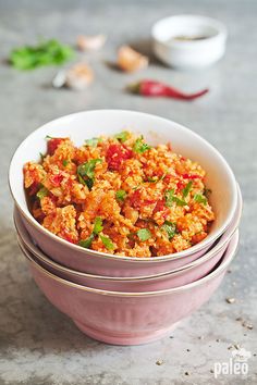 three bowls filled with food sitting on top of a marble counter next to garlic and pepper