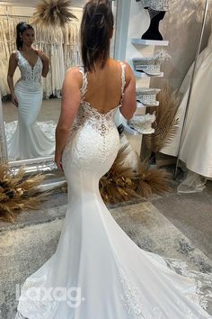 a woman is looking at her wedding dress