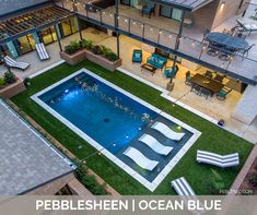 an aerial view of a backyard with a pool and patio furniture in the foreground