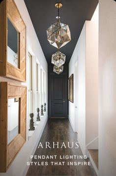 an image of a hallway with chandelier hanging from the ceiling and wood flooring