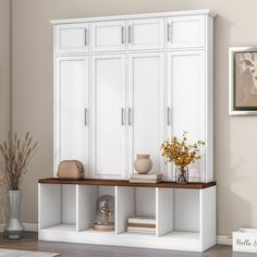 a white cabinet with shelves and vases on top