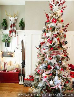 a decorated christmas tree in the corner of a living room with red and white ornaments