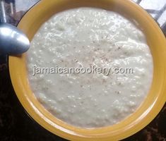 a yellow bowl filled with white liquid on top of a table