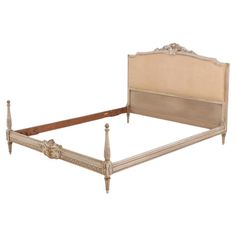 an antique style bed frame with beige linen