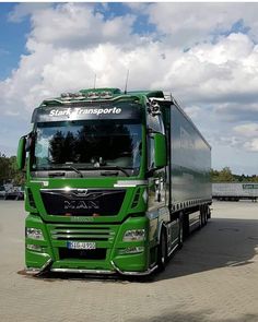 a green semi truck parked in a parking lot